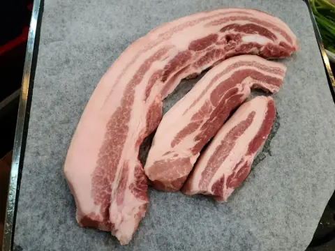 Thick-cut rashers of dry cured back bacon on butcher's paper
