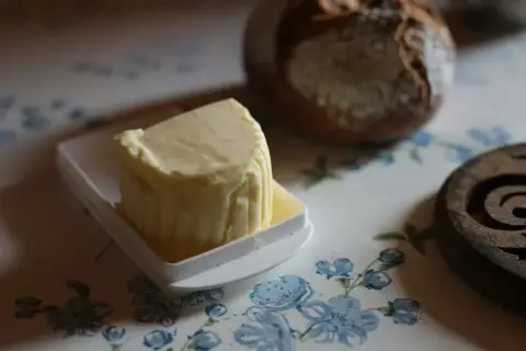 A block of cultured Long Meadow butter on a dish beside a loaf