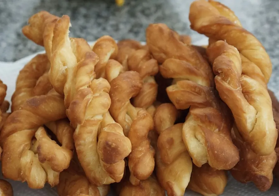 Golden twisted cheese straws piled on a plate