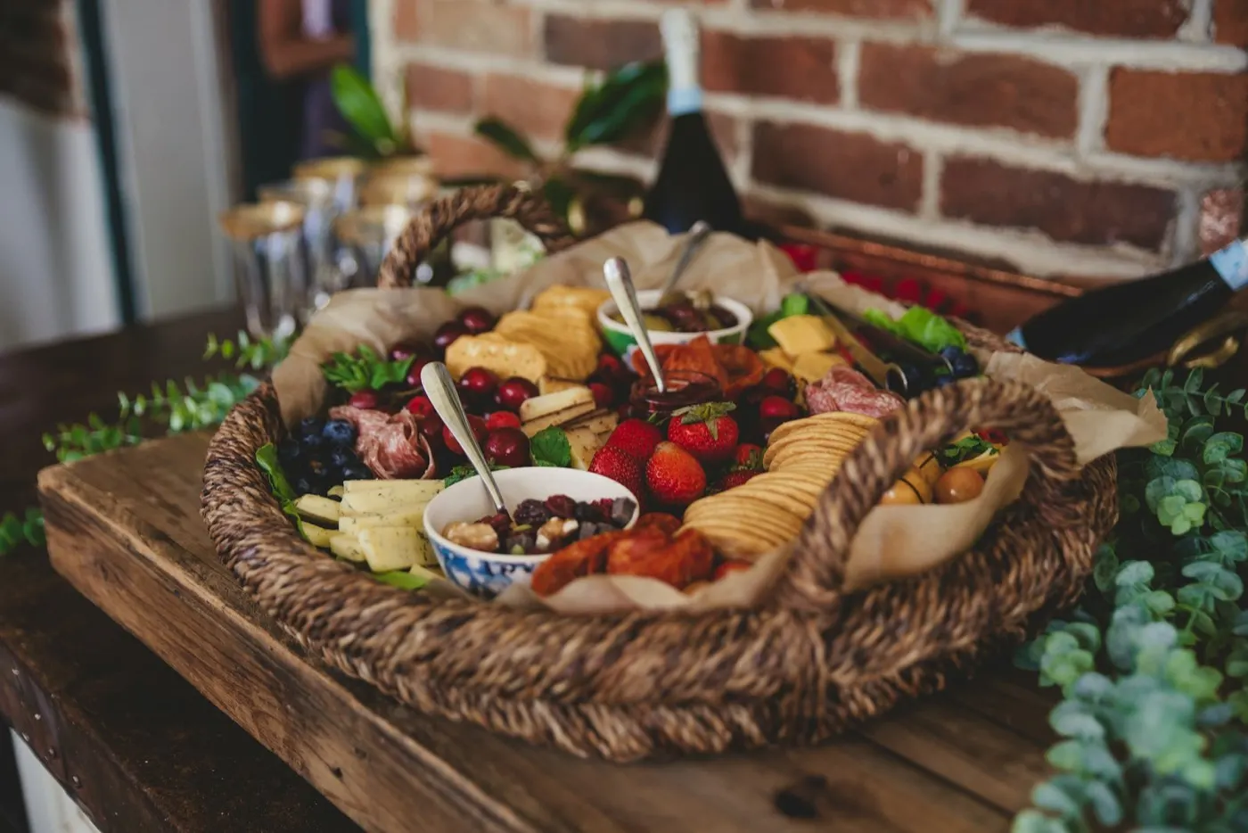 An open hamper spread with cheese, fruit and preserves